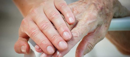 Young hand holding elderly hand